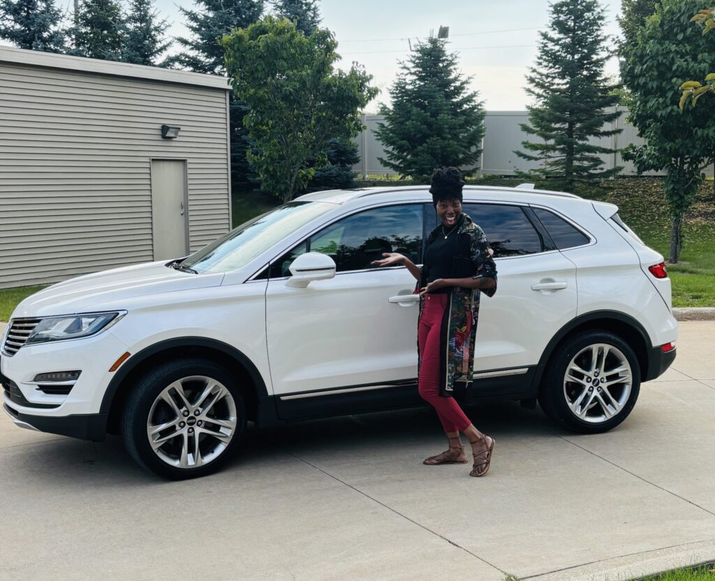 Woman standing next to car she purchased through ADVOCAP Work N Wheels program