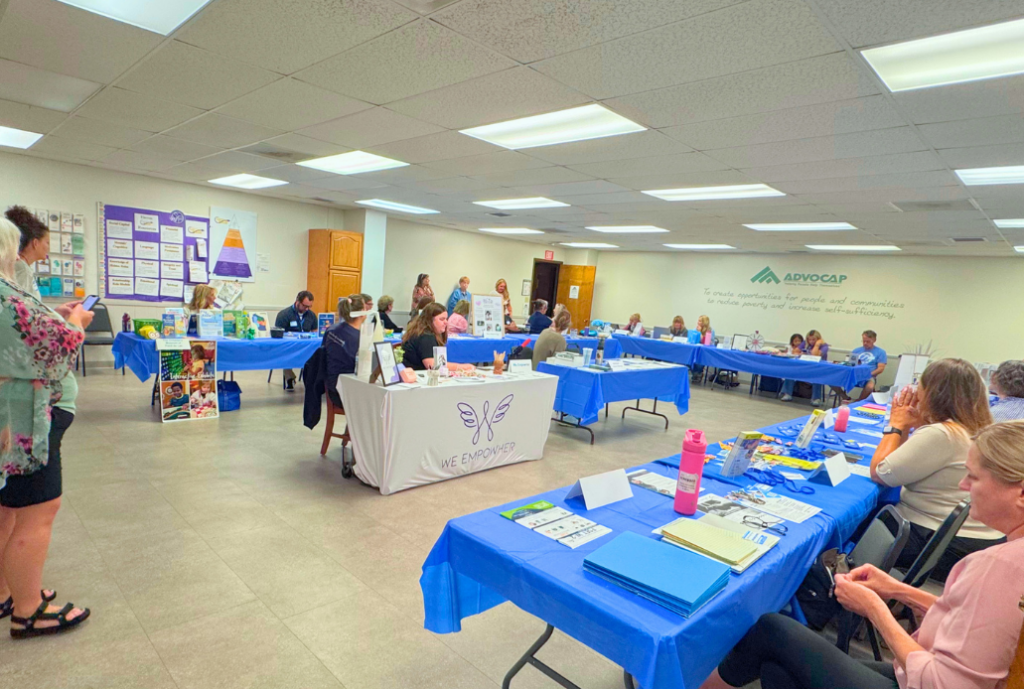 resource booth tables set up around large ADVOCAP office room for resource fair with 18 organizations represented