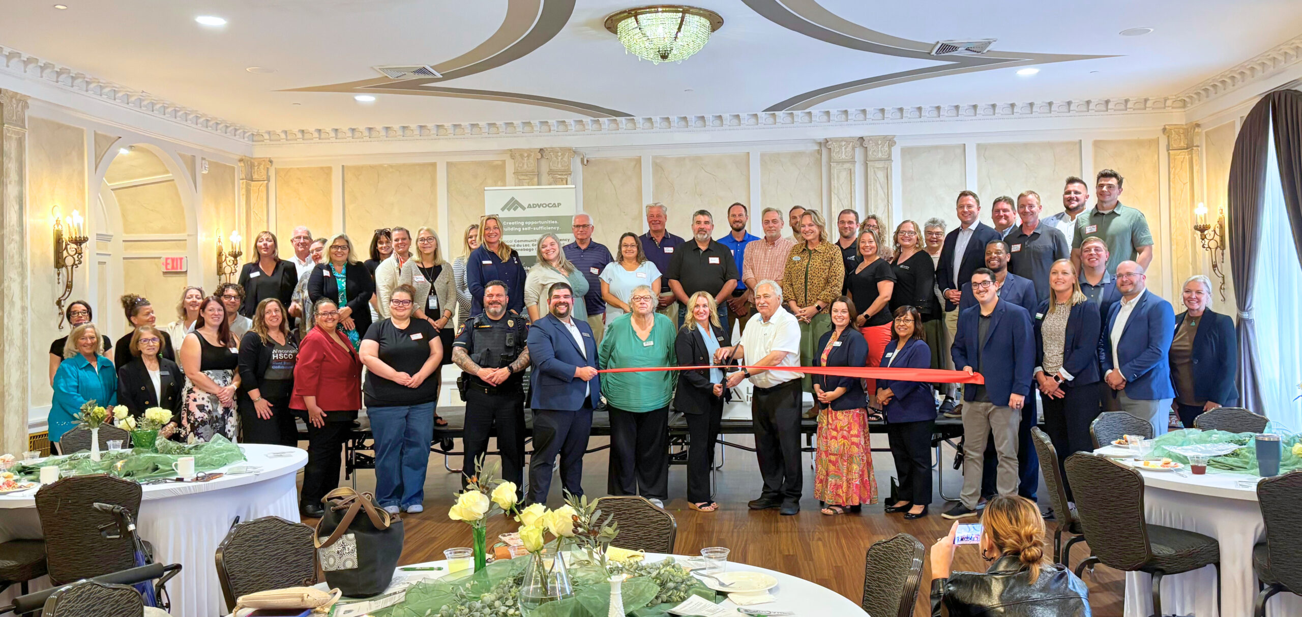 All attendees stand behind ribbon cutting ceremony